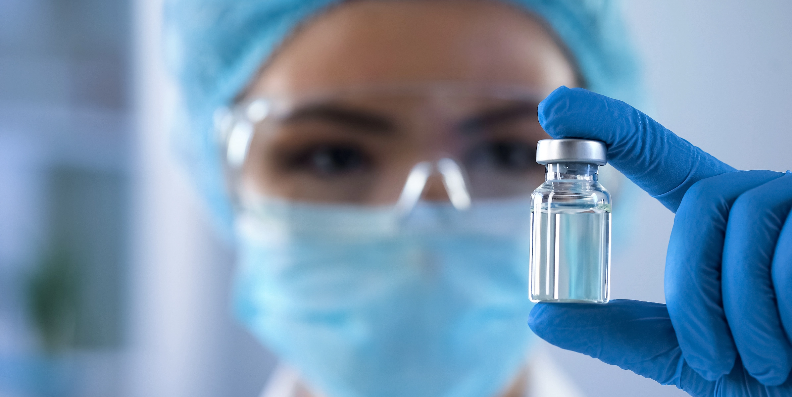 researcher looking at a vial